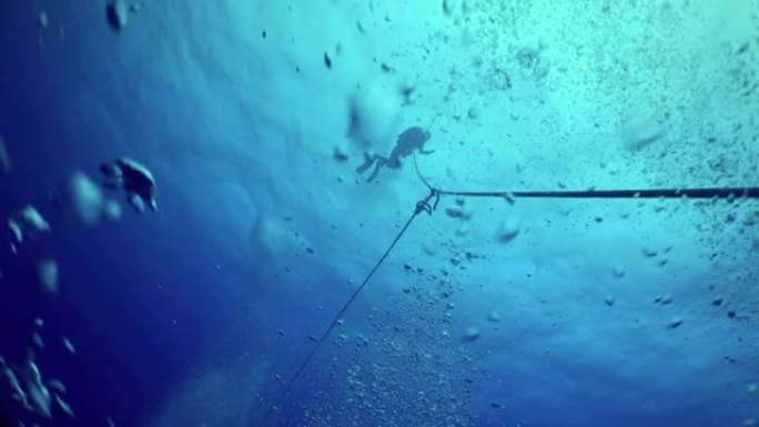 英勇的潜水员通过电缆降落到海底。