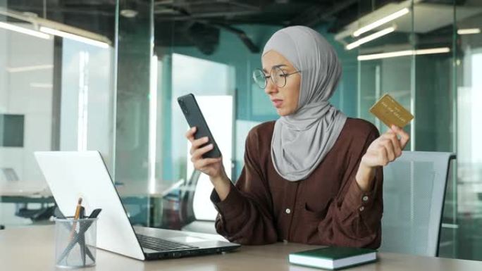 戴着信用卡的穆斯林女商人在盖头上遇到问题，在线订单不良服务被阻止的银行帐户失败
