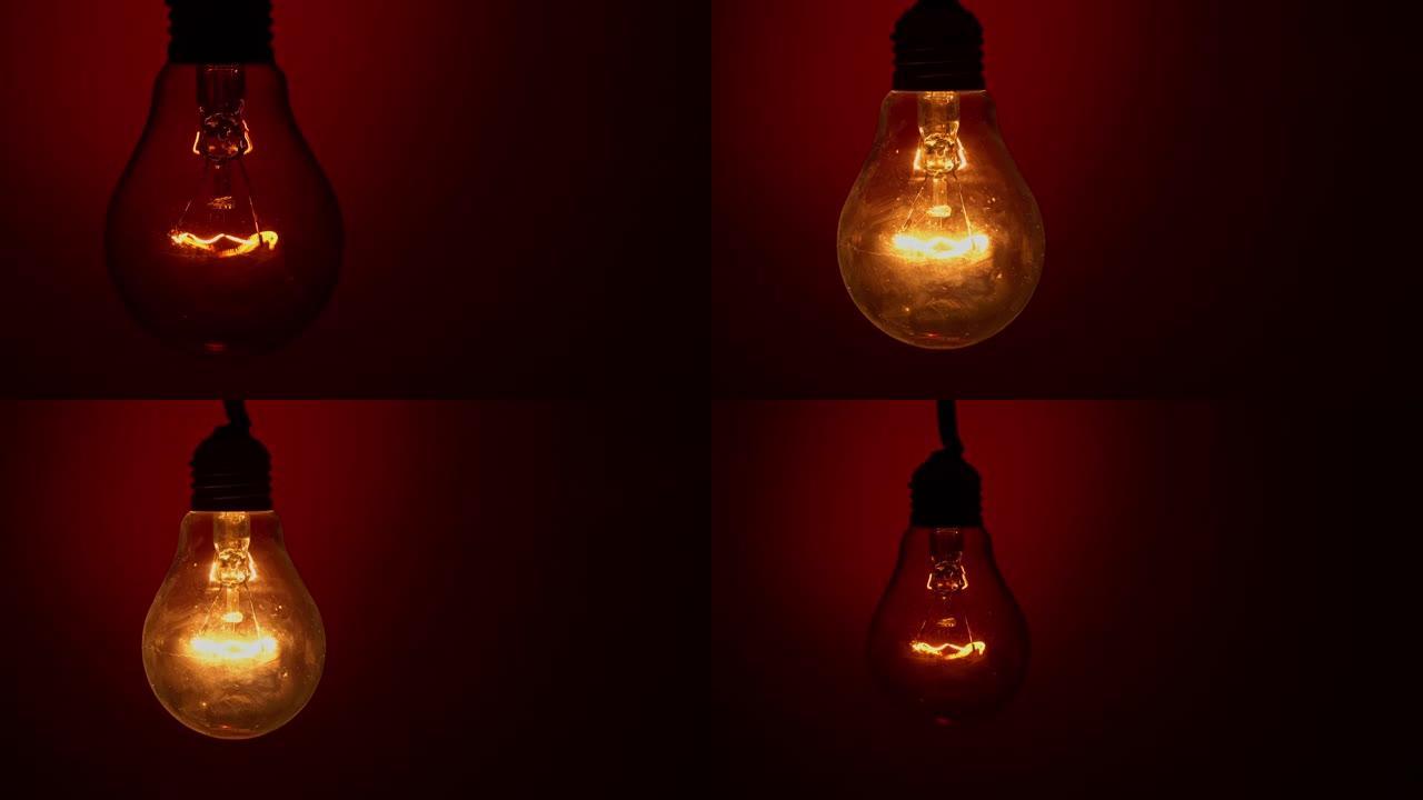 灯泡点亮并在黑暗中的红色背景下熄灭