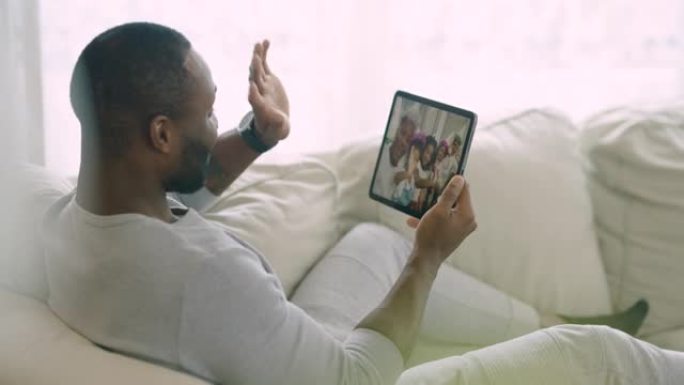 非洲民族的快乐年轻人坐在家里放松与家人进行视频通话。