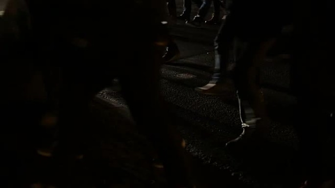 一群坚决的学生走在黑暗的城市街道上登台