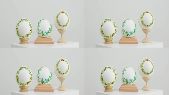 架子上的三个白色鸡蛋的特写在蛋壳上绣花丝带示例技术精美的装饰品手工制作的复活节复活节彩蛋装饰在鸡蛋上