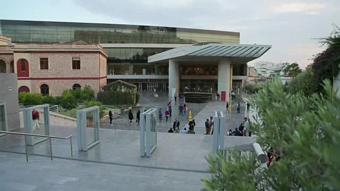 人群在大型展览中心外行走，现代玻璃
