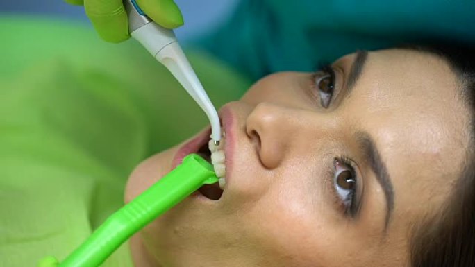牙医从牙齿清洗蓝色凝胶，美容牙科，专业帮助