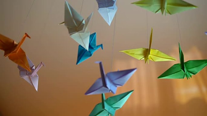许多折纸鸟在阳光明媚的背景下在风中挥舞，日本传统艺术