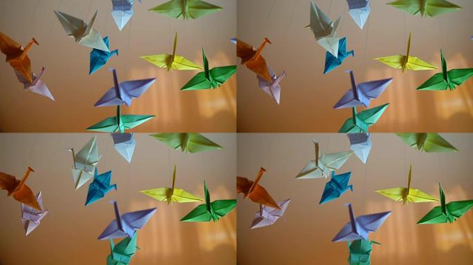 许多折纸鸟在阳光明媚的背景下在风中挥舞，日本传统艺术
