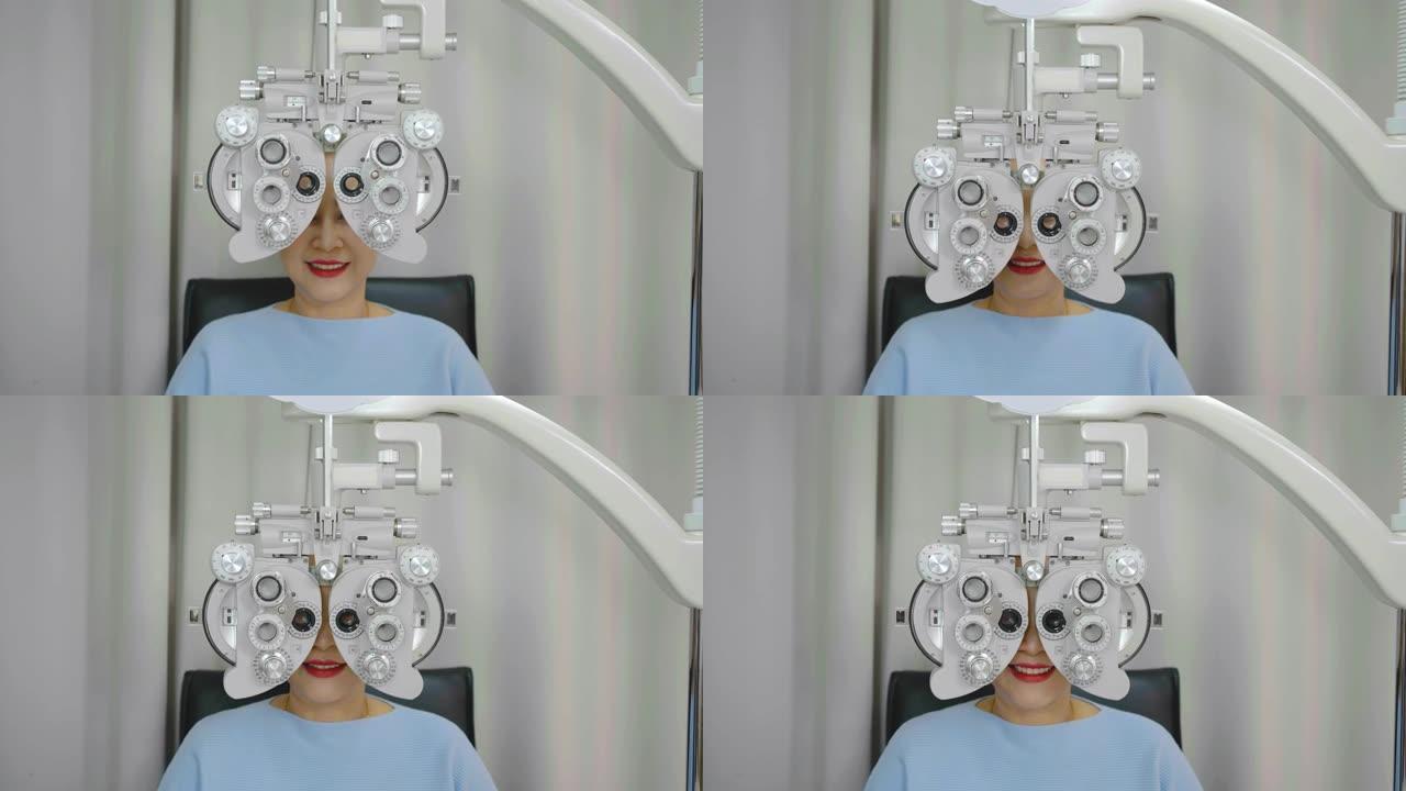 微笑的亚洲高级女性在光学验光仪上做眼部检查，在诊所或眼镜店用验光机检查她的眼睛，眼科概念。