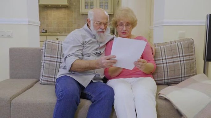 老年夫妇一起看家里的房租账单