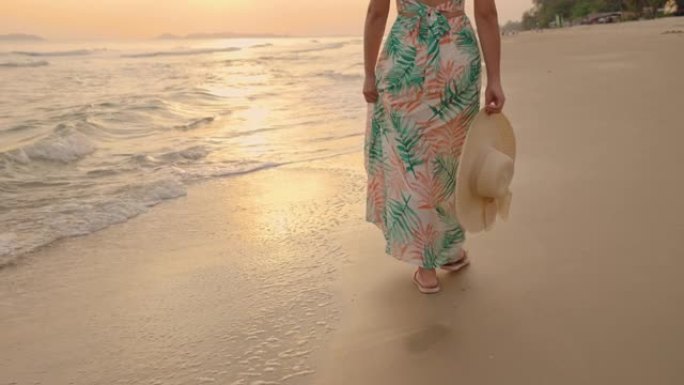 她在日落的海滩上散步。
