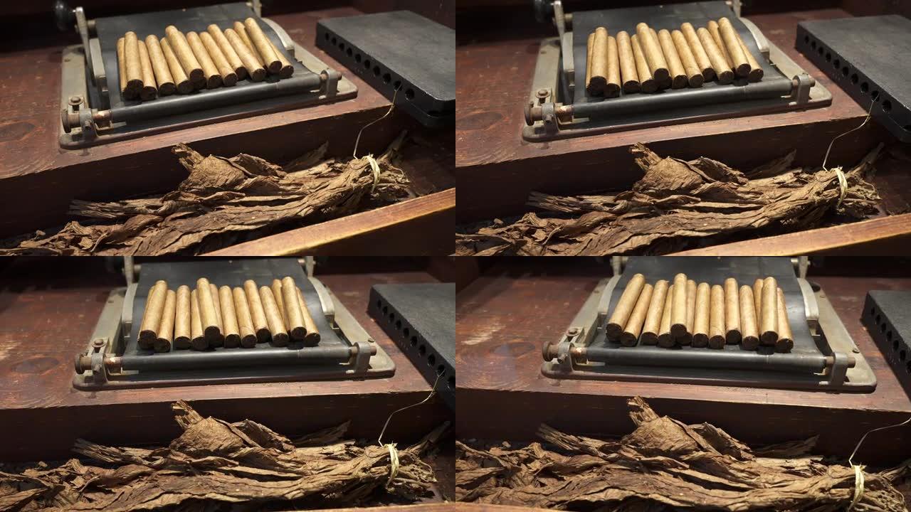 干燥的烟叶和一堆新鲜的手卷多米尼加雪茄放在木桌上。世界上最好的雪茄