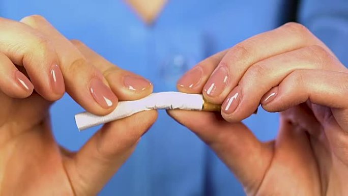女性双手掰开香烟，预防肺癌，不吸烟