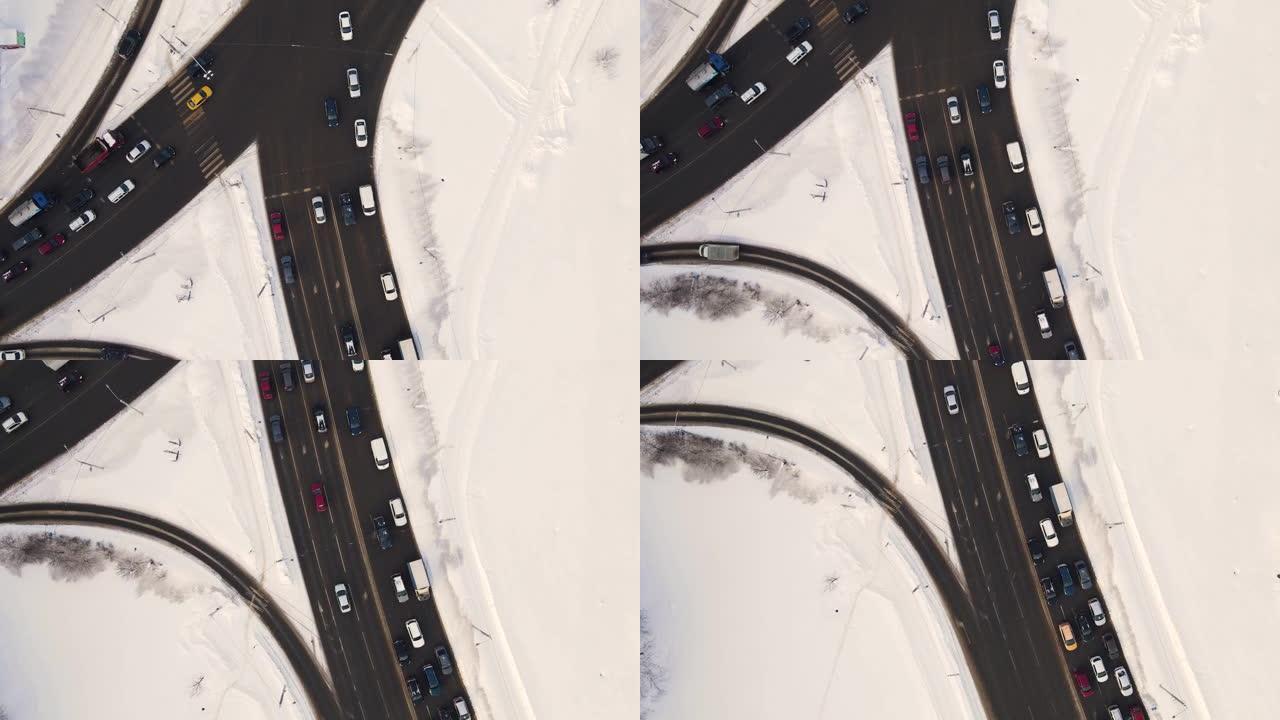 鸟瞰冬天有汽车的白雪皑皑的城市十字路口。