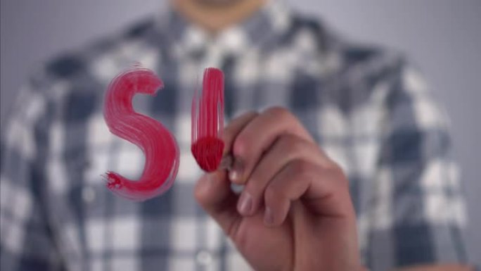 一个年轻人在玻璃上画了一个带问号的“性”字。一个穿着格子衬衫的男人用画笔和红色颜料画画。特写镜头。4