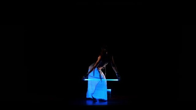 年轻的吉普赛女子在紫外线下跳舞霓虹灯表演