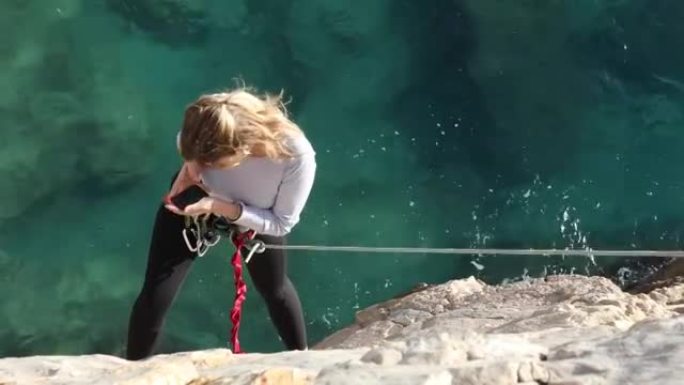 女性登山者在拍摄自拍照时挂在绳子的末端