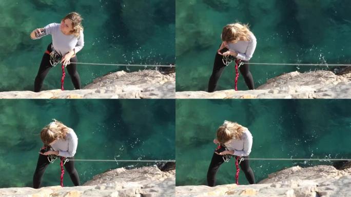 女性登山者在拍摄自拍照时挂在绳子的末端