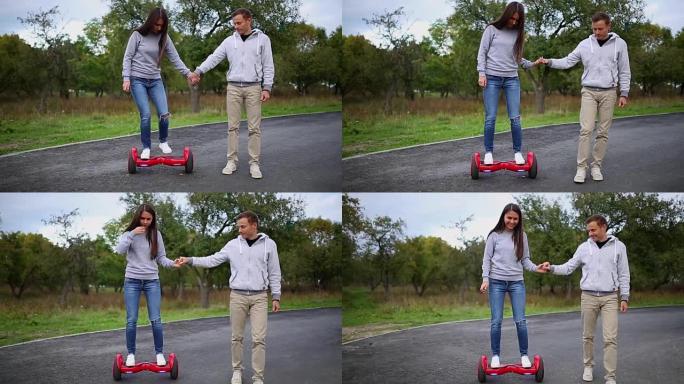 年轻的男人和女人骑在公园的气垫板上。内容技术。一个新的运动。双轮自平衡电动滑板智能特写。户外电动滑板