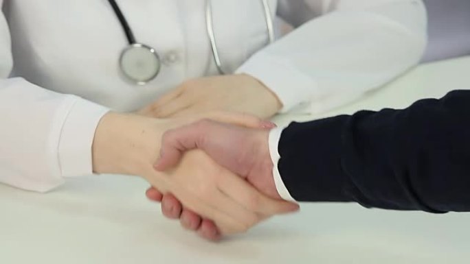 医药销售代表与女医生握手，达成交易
