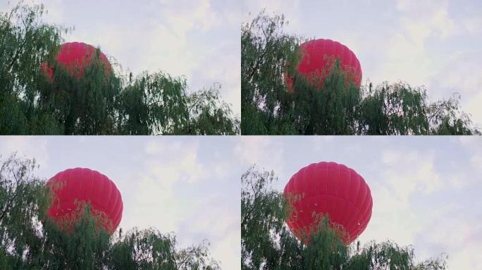 红色热气球飞越树木，休闲活动和运动，极限