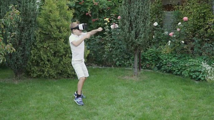 小男孩在花园里使用虚拟现实眼镜