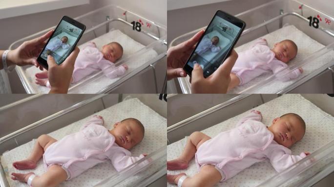 拍手机照片她刚出生的孩子的年轻母亲睡在妇产医院的病床上