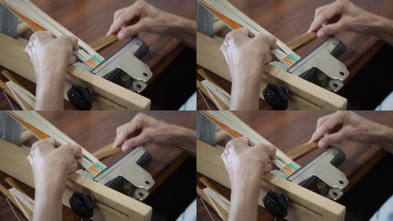 木棍被用来手工分离有色纱线，为编织做准备，拍摄为特写镜头