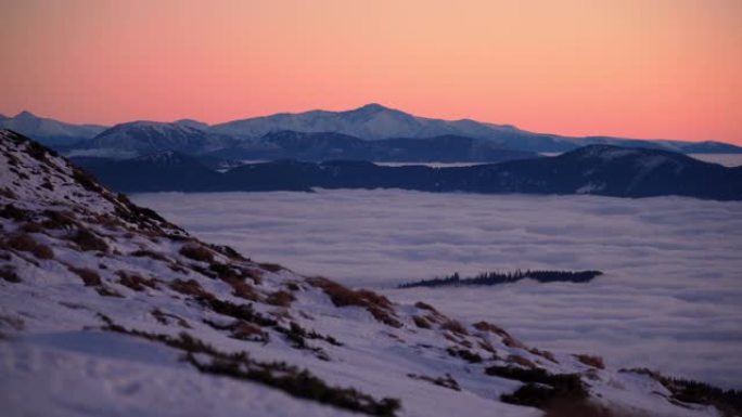 雪，云和雾在下面滚动的山脉的风景