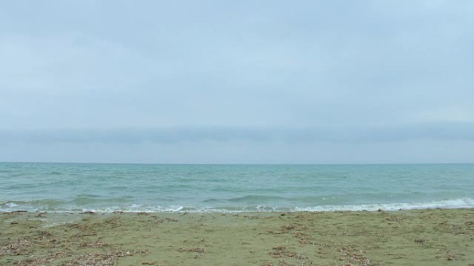 波涛汹涌的海水，浪花飞溅，风吹在沙滩上。