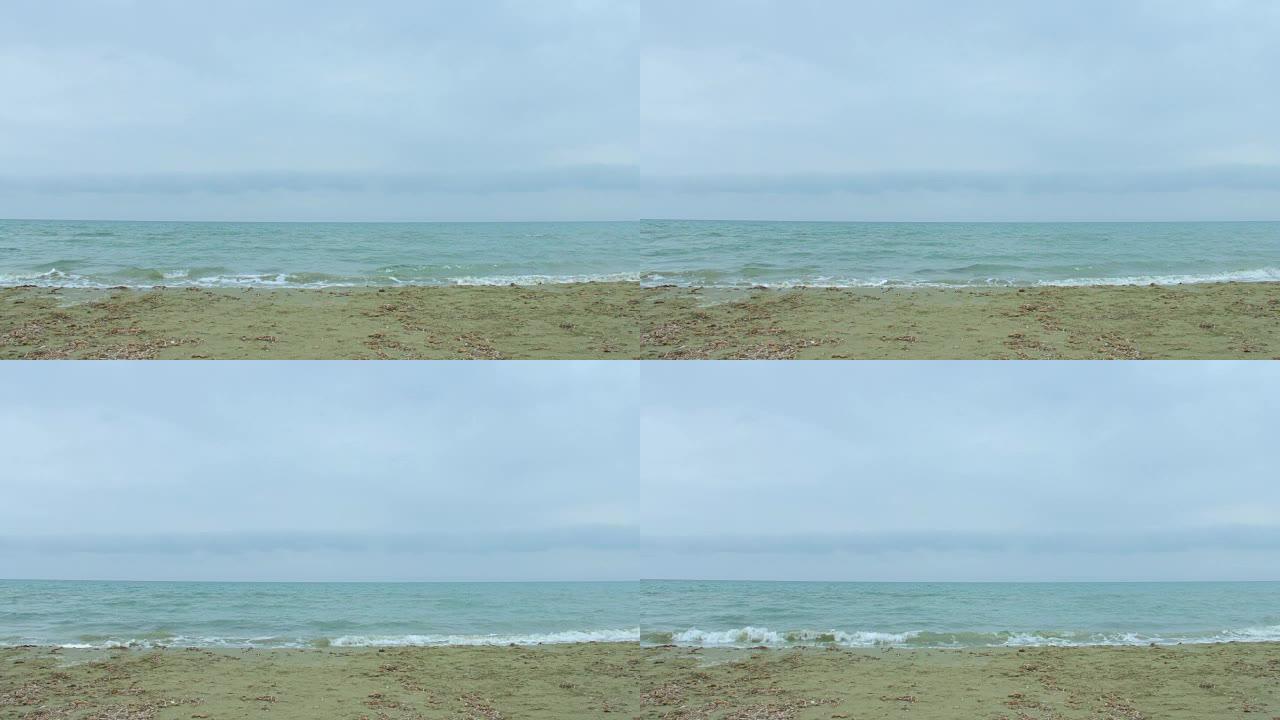 波涛汹涌的海水，浪花飞溅，风吹在沙滩上。