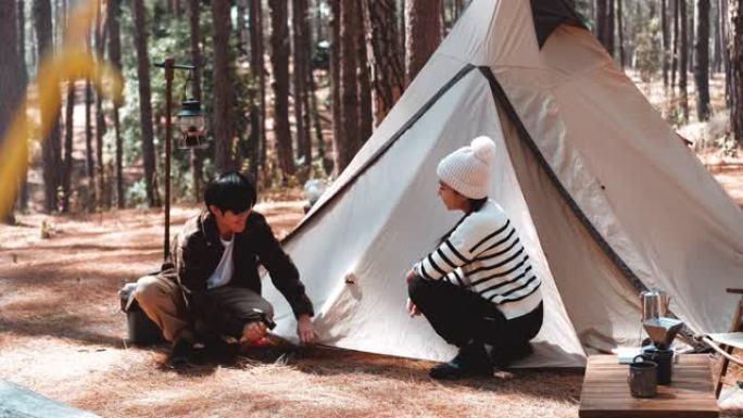 快乐的时刻。夏天，夫妇坐在松树林中间的露营地里
