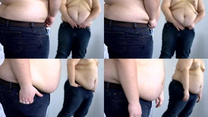 胖肚子下的沉重男人勒紧牛仔裤腰带，暴饮暴食问题，肥胖