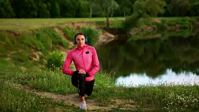 一个穿着粉红色外套的女孩正在准备跑步热身，并通过电话听耳机听音乐