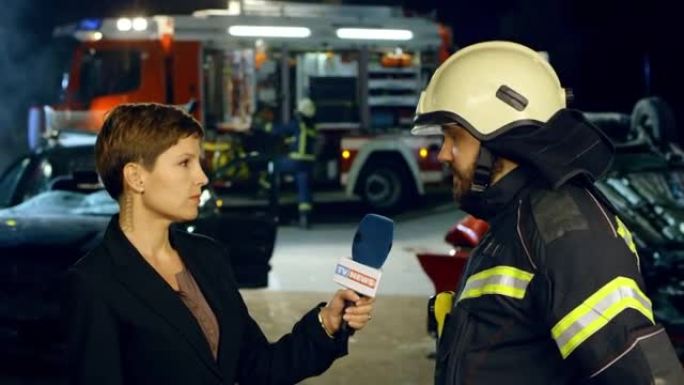 女新闻记者采访一名男消防员夜间在车祸现场直播