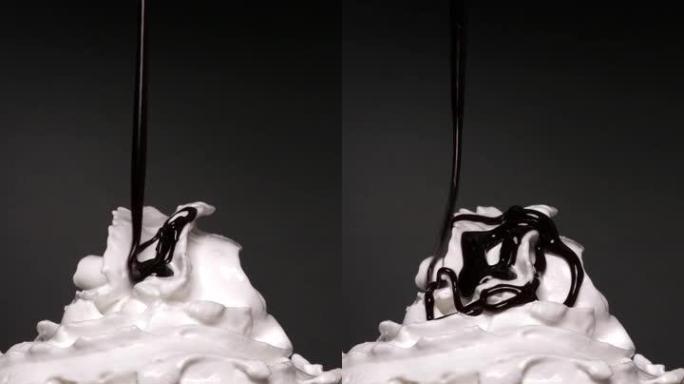 垂直视频正面视图，在黑色背景上的透明塑料杯中，在冰镇咖啡上的鲜奶油上的巧克力rach。