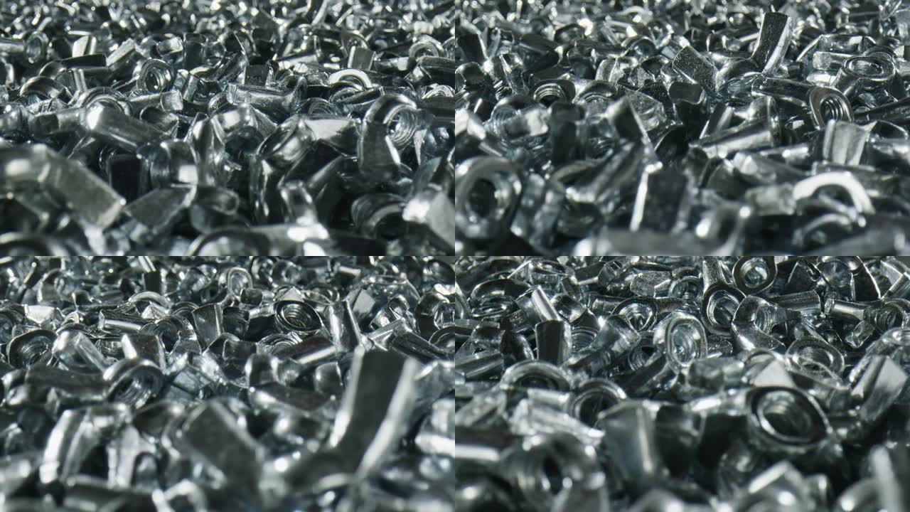 几十个银色闪亮的带紧固件的分散金属螺母-特写