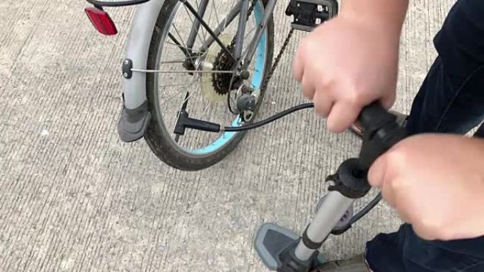 特写镜头的人给自行车车轮充气，将空气泵入轮胎