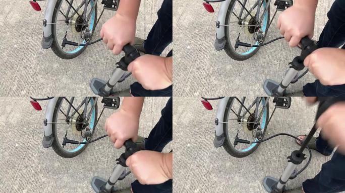 特写镜头的人给自行车车轮充气，将空气泵入轮胎