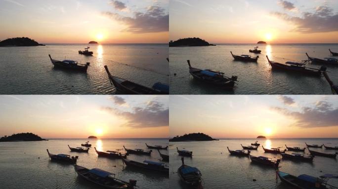泰国利佩岛芭堤雅海滩的海洋和日落，有剪影渔船