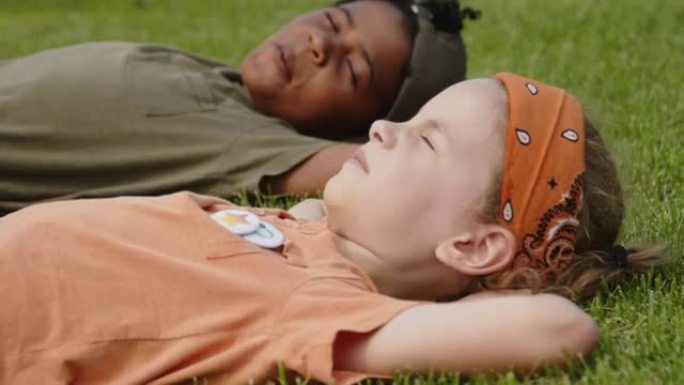 多种族的孩子在公园的绿草地上放松