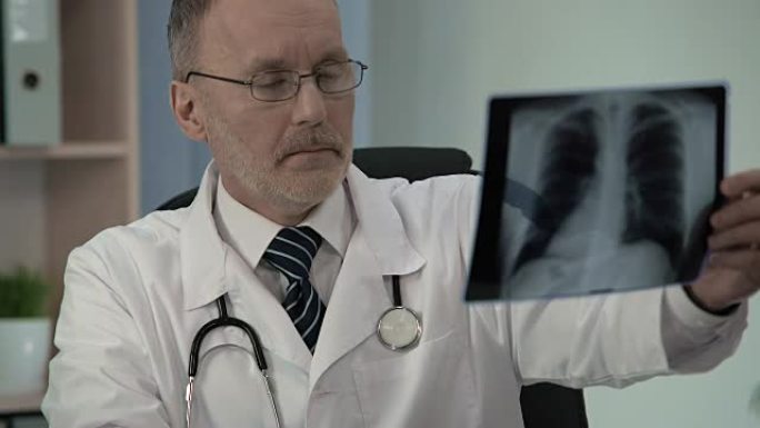 男性肺科医生仔细检查胸部x线，寻找病理