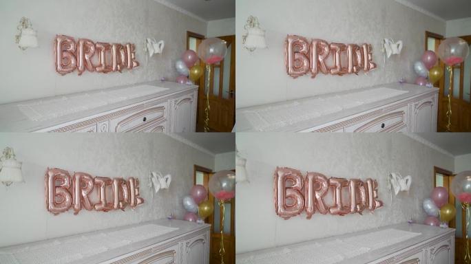 挂在白色墙上的粉色婚礼气球装饰品
