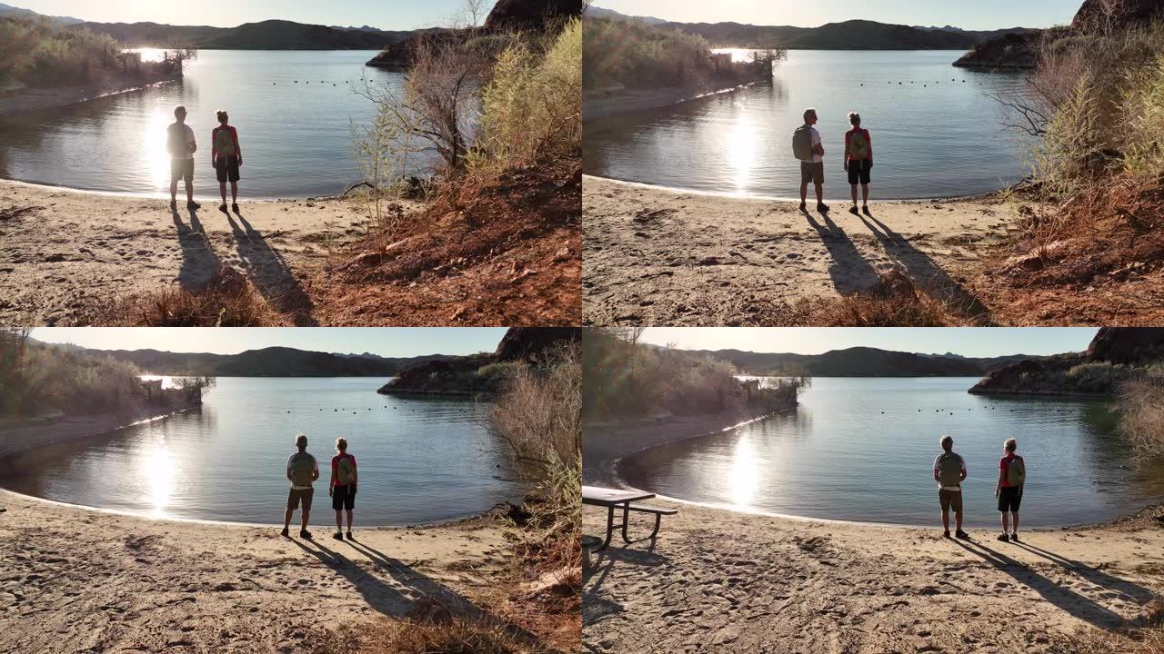 成熟的男性和女性徒步旅行者在空旷的海滩上放松