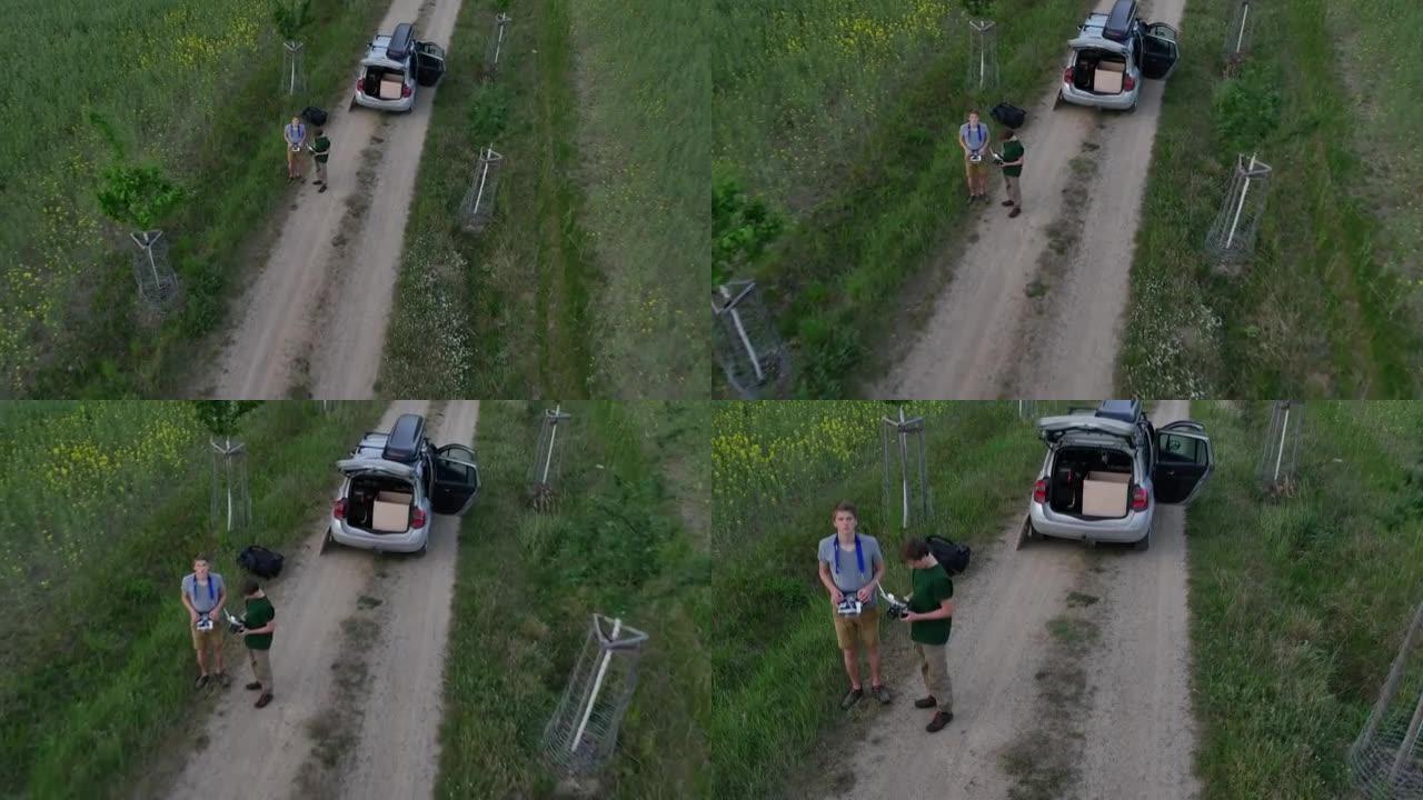 两名年轻男性在乡村土路上驾驶无人机