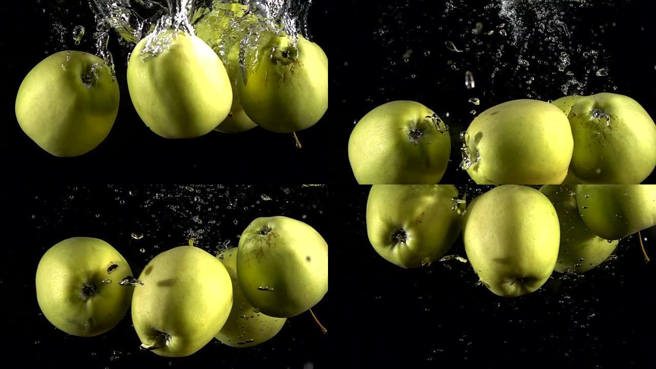 慢动作黄色苹果落在黑色背景下的水下。美丽的新鲜水果在水族馆里飞溅。有机水果，健康食品，饮食，概念。以