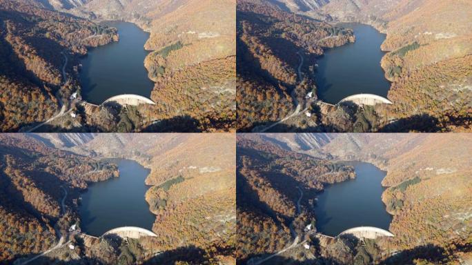秋天在山中间的拱坝水力发电厂的空中无人机视图