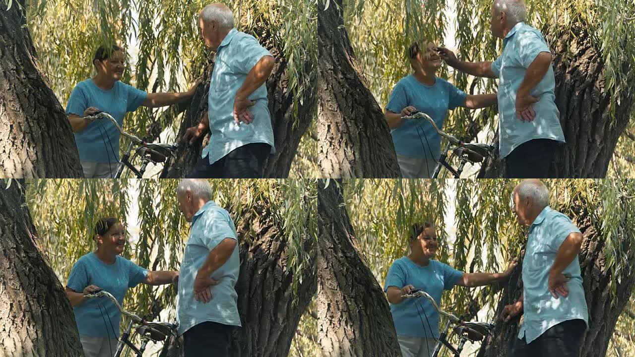 老人和女人在柳树下说话