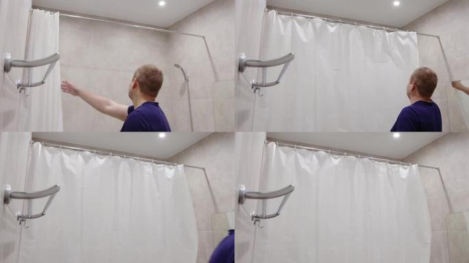 一名男子在浴室关闭浴帘以防止飞溅的水。现代浴室