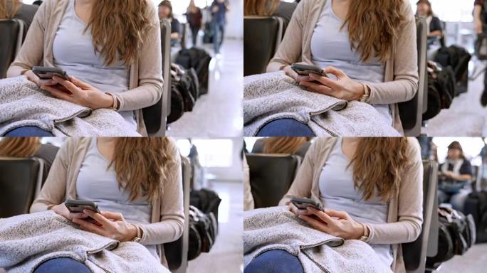 女人坐在机场门口时拿着手机广告滚动它