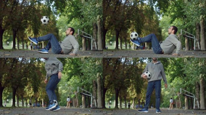 户外动作镜头，职业足球运动员用球表演自由式技巧。自信的年轻足球运动员在公园的夏日里炫耀杂耍技巧
