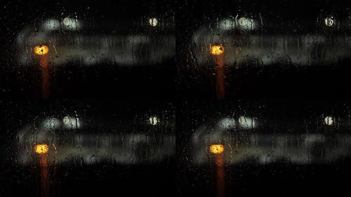 玻璃上的雨滴。到了晚上，在光斑的背景下，水滴滴在玻璃上并流下，正在下雨。特写